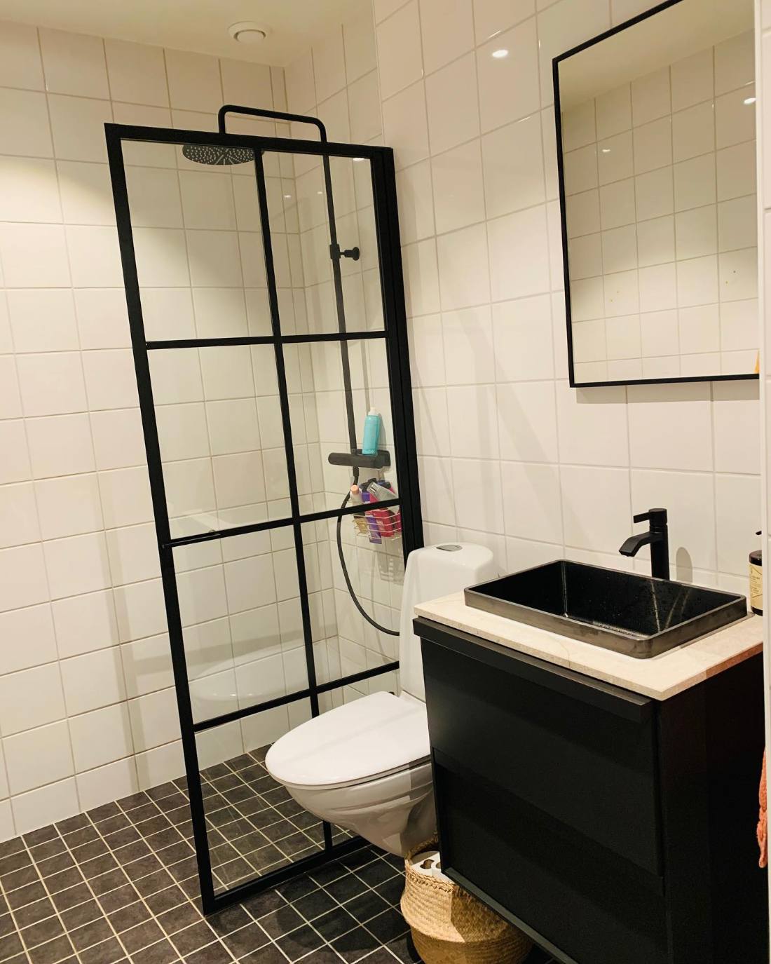 Renoverat badrum med svart duschvägg och svart handfat